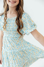 Mila & Rose Buttercup Blooms smocked ruffle dress for toddlers, featuring a floral pattern and delicate ruffle details.
