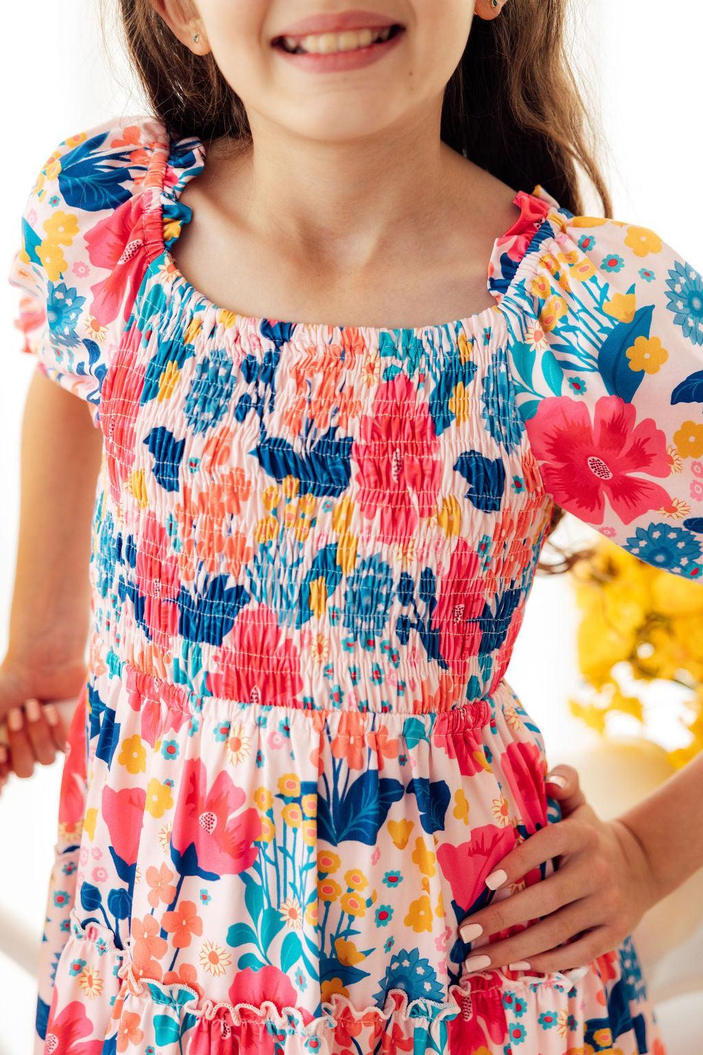 Mila & Rose® Sunshine Garden smocked ruffle dress for toddler girls with floral print and ruffled sleeves, perfect for spring.