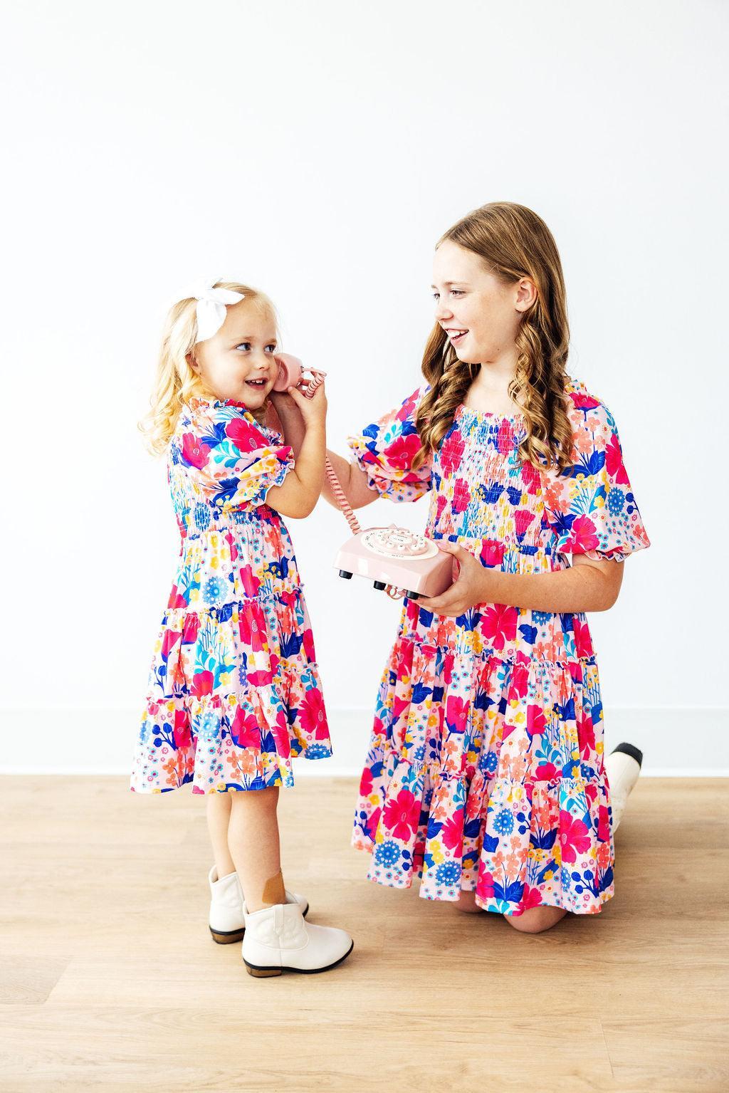 Mila & Rose children's smocked ruffle dress in sunshine garden print, 2T size, with ruffled neckline and floral pattern.