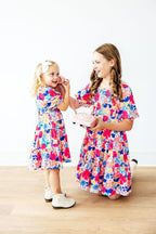 Mila & Rose children's smocked ruffle dress in sunshine garden print, 2T size, with ruffled neckline and floral pattern.