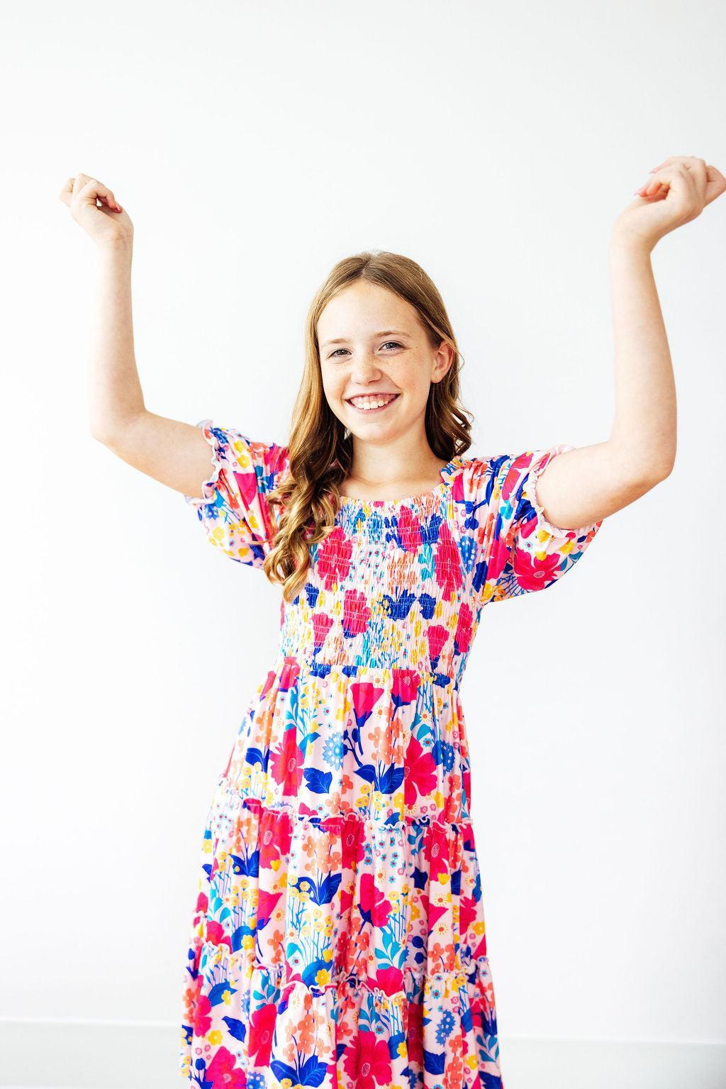 Mila & Rose® Sunshine Garden smocked ruffle dress for toddlers, with floral pattern, ruffle sleeves, and a fitted smocked bodice.