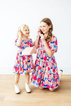 Mila & Rose Sunshine Garden smocked ruffle dress for toddlers, featuring floral pattern, ruffled sleeves, and elastic smocked bodice.