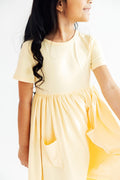 Butter yellow Mila & Rose short-sleeve twirl pocket dress for baby girls, featuring a playful, flowy design with side pockets.
