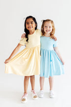 Butter yellow Mila & Rose S/S Twirl Pocket Dress for babies, featuring short sleeves and a playful twirl skirt design.