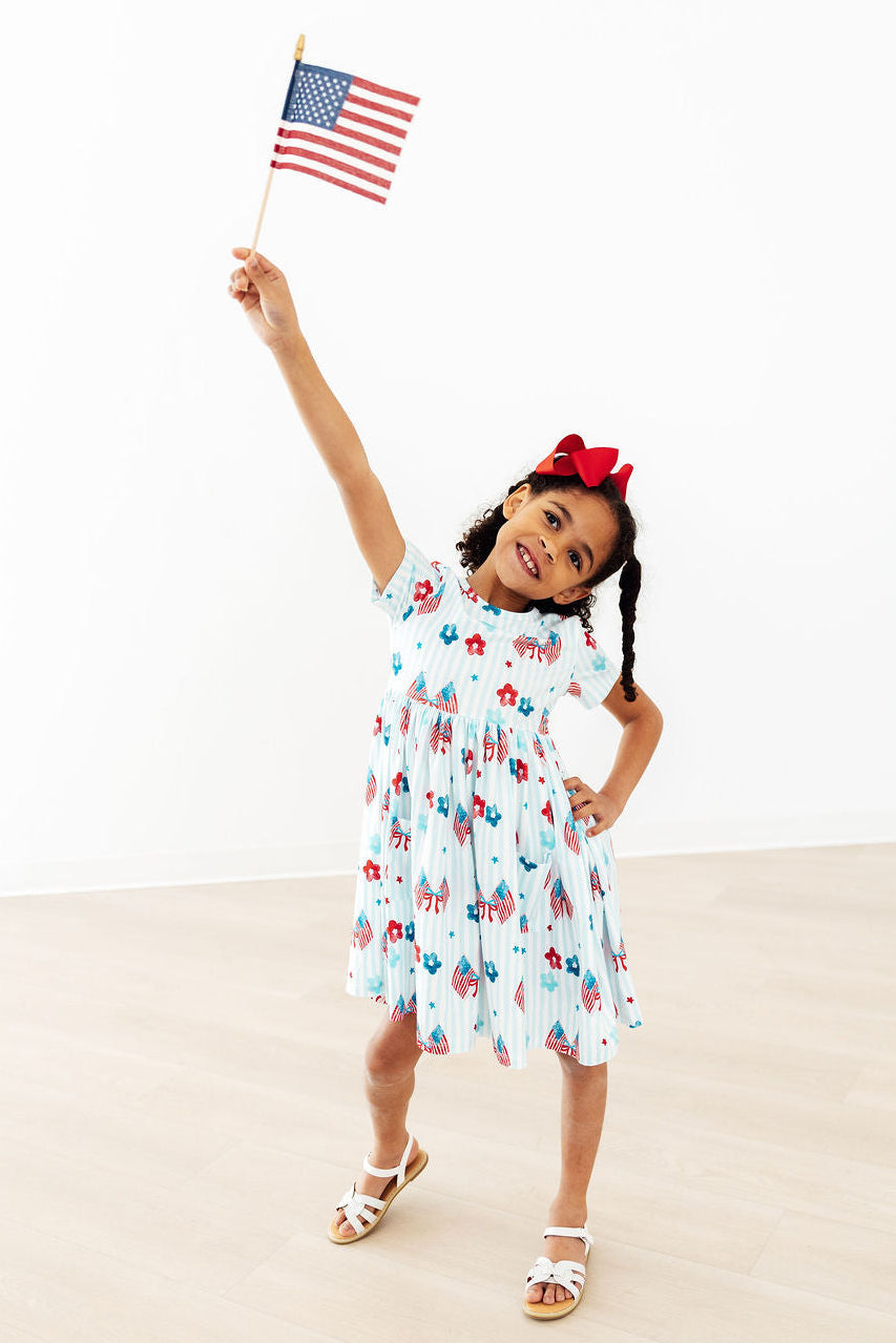 Mila & Rose® Home of the Brave S/S Twirl Pocket Dress for babies, featuring a playful design and short sleeves.