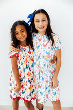 Mila & Rose rainbow rooster print short-sleeve pocket twirl dress for toddlers, featuring colorful rooster pattern and playful design.