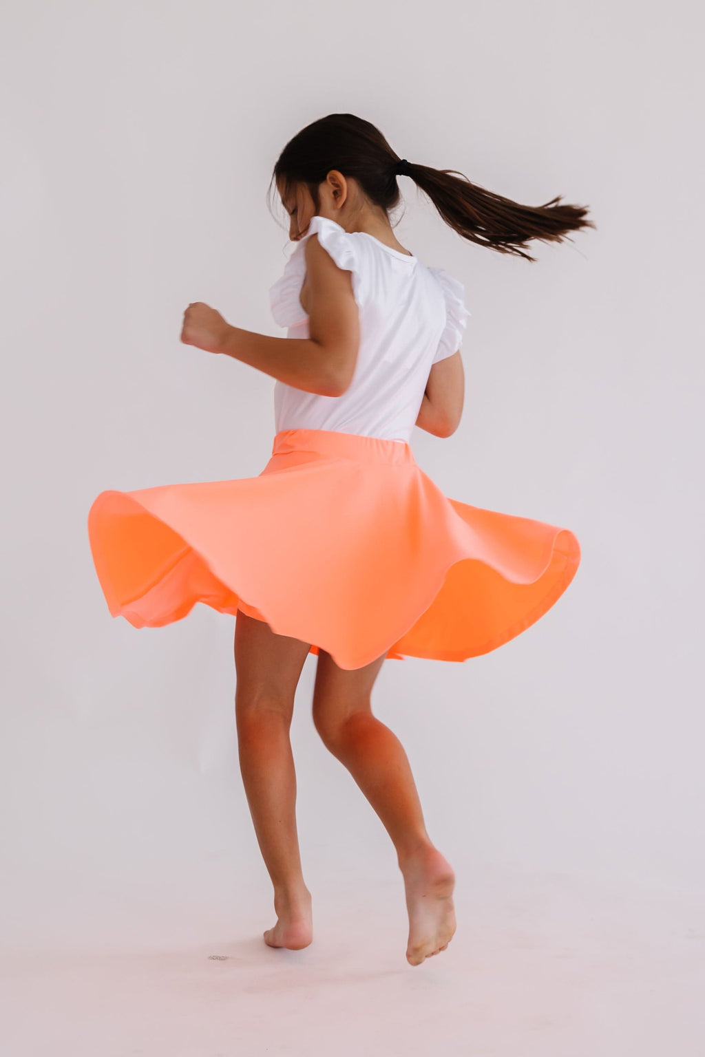 Neon coral Mila & Rose twirl skort for 6-12 months, featuring a playful ruffled design and comfortable fabric.