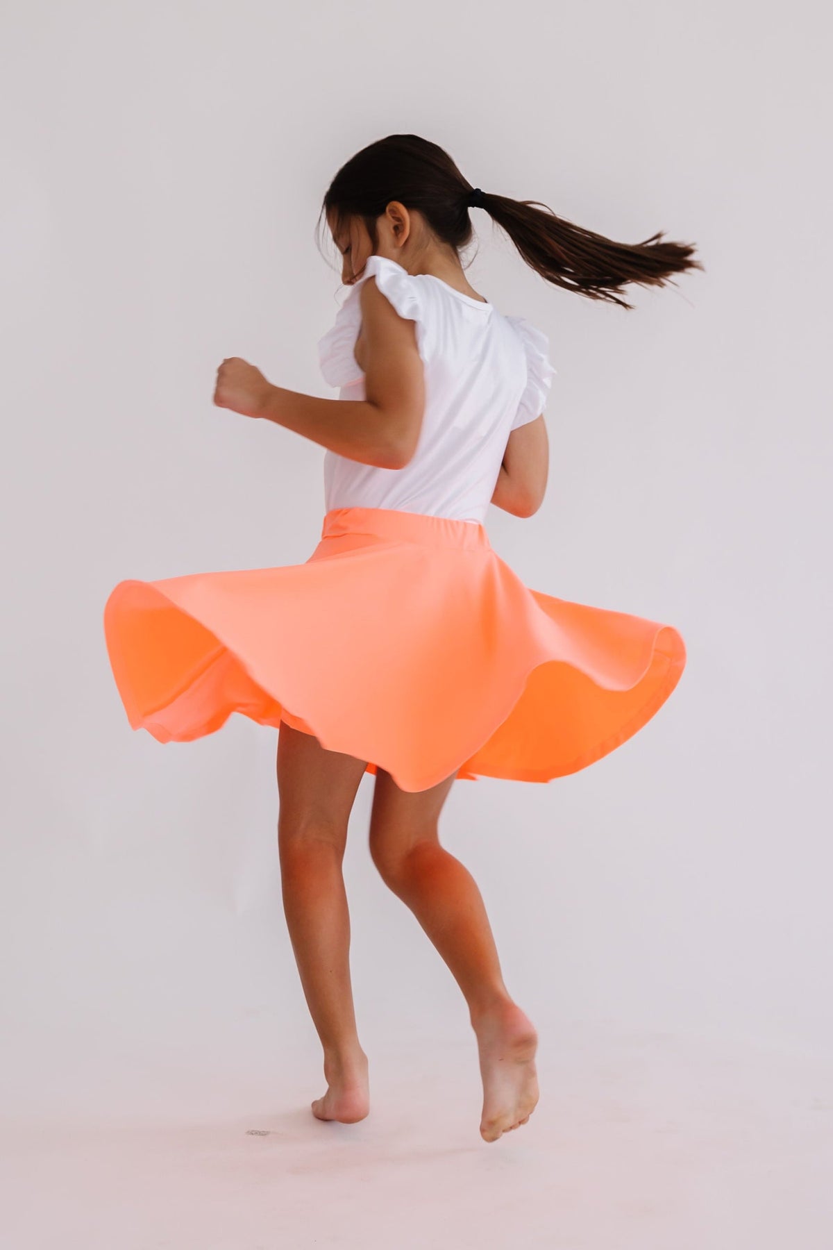 Neon coral Mila & Rose twirl skort for 6-12 months, featuring a playful ruffled design and comfortable fabric.