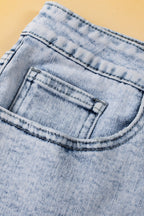 Light blue acid wash crossed raw edge denim shorts from Mommas Hive, featuring distressed hem and casual fit.