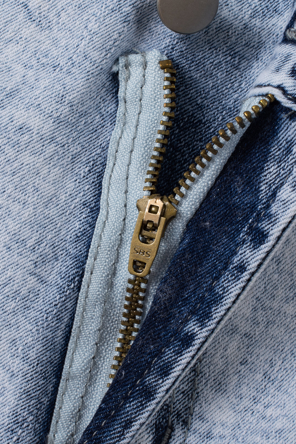 Light blue acid wash denim shorts with crossed raw edges from Mommas Hive, featuring a casual, distressed style.
