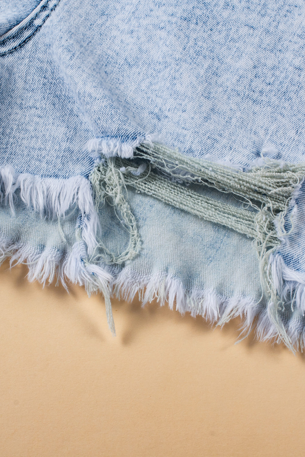 Light blue acid wash crossed raw edge denim shorts by Mommas Hive, casual bottoms with distressed style and raw hem details.
