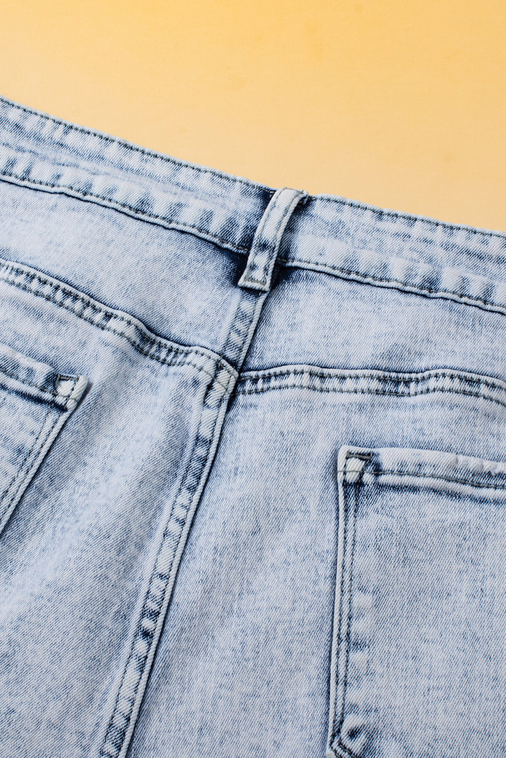 Light blue acid wash crossed raw edge denim shorts by Mommas Hive, casual bottoms with distressed style and raw hem detail.