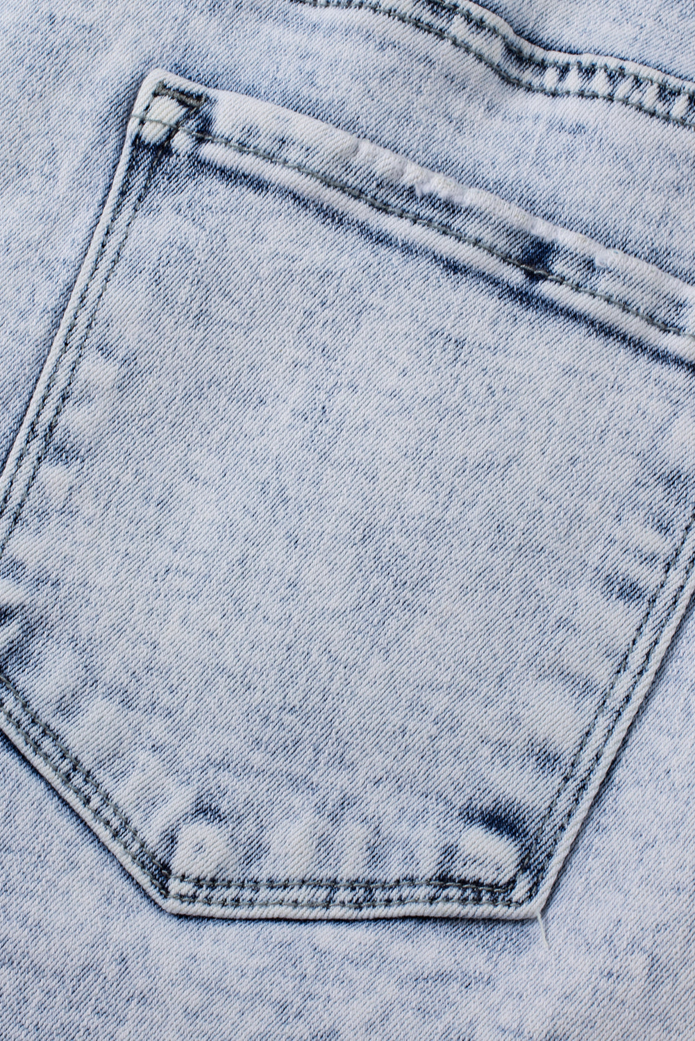 Light blue acid wash crossed raw edge denim shorts from Mommas Hive, casual bottoms with distressed detail and stretchy fit.