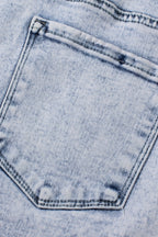Light blue acid wash crossed raw edge denim shorts from Mommas Hive, casual bottoms with distressed detail and stretchy fit.