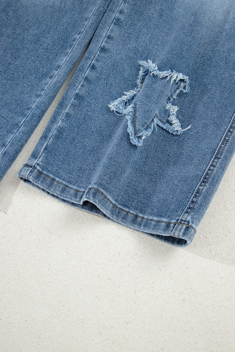 Stone blue star patchwork cropped wide-leg high waist jeans by Mommas Hive, showcasing distressed details and relaxed fit.