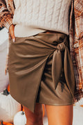 Coffee-colored faux leather mini skirt with bowknot detail from Mommas Hive, stylish bottoms for a trendy look.
