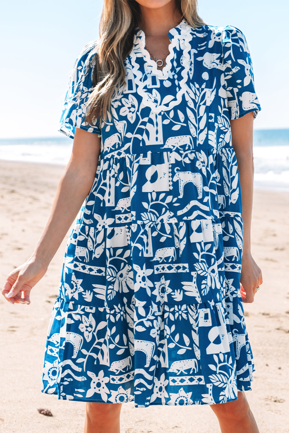 Blue floral loose dress with ricrac trim, split neck, and short sleeves from Mommas Hive, made of lightweight polyester fabric.