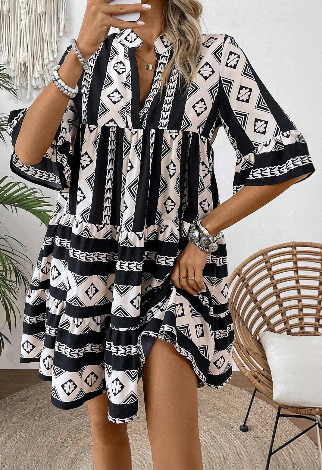 Black geometric print V-neck ruffled dress from Mommas Hive, a stylish mini dress with a flattering fit and ruffled details.