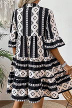 Black geometric print V-neck ruffled mini dress by Mommas Hive, featuring a stylish design and lightweight polyester fabric.