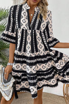 Black geometric print V-neck ruffled mini dress by Mommas Hive, showcasing stylish ruffle details and a fitted silhouette.