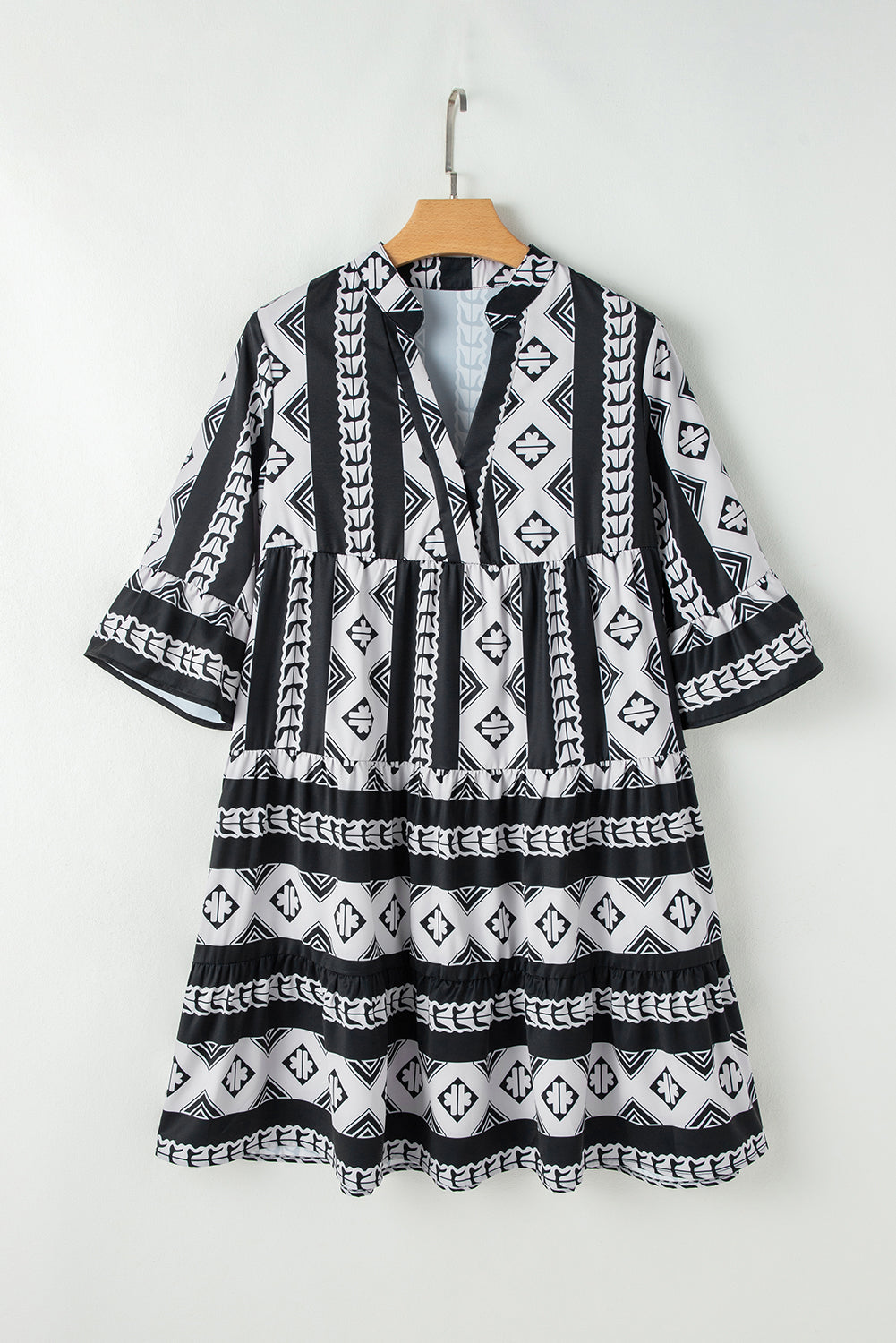 Black geometric print V-neck ruffled mini dress by Mommas Hive, featuring a stylish design and lightweight polyester fabric.