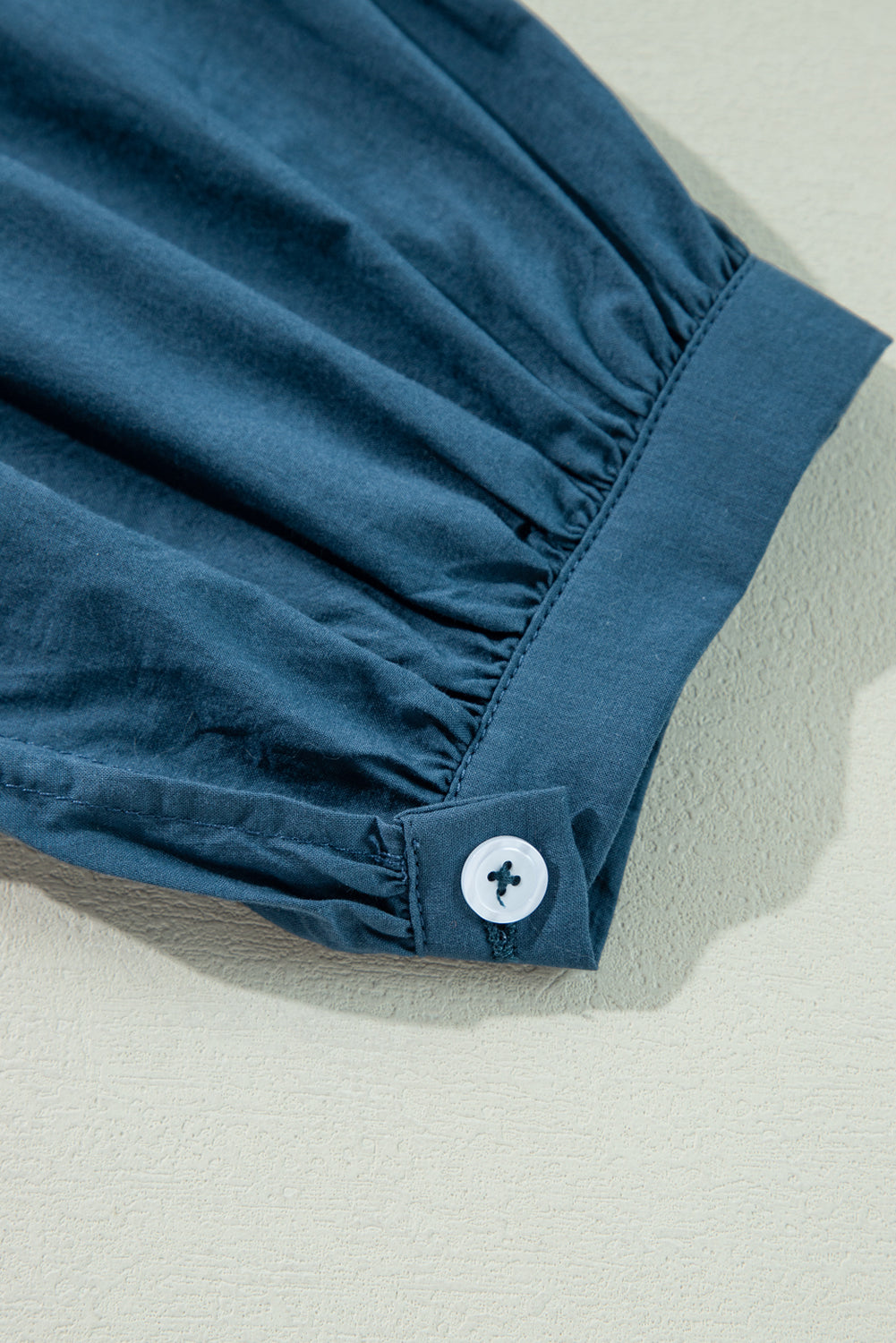 Prussian Blue 3/4 sleeve shirred high waist buttoned mini dress by Mommas Hive, made of 100% cotton, displayed on a hanger.