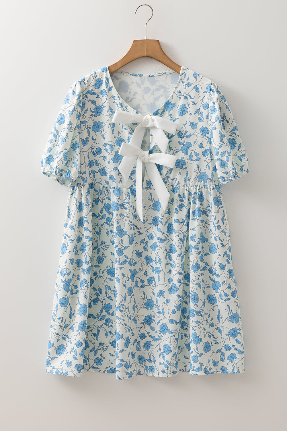 Sky blue floral mini dress with contrast bow and puff sleeves, from Mommas Hive, made of lightweight polyester fabric.