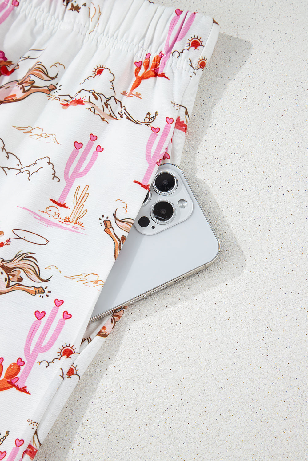 White cowgirl country print pajamas set from Mommas Hive, soft loungewear with comfortable polyester and elastane blend.