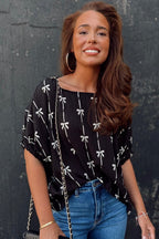 Black bow print puff short sleeve top from Mommas Hive, stylish blouse with puff sleeves and elegant design.