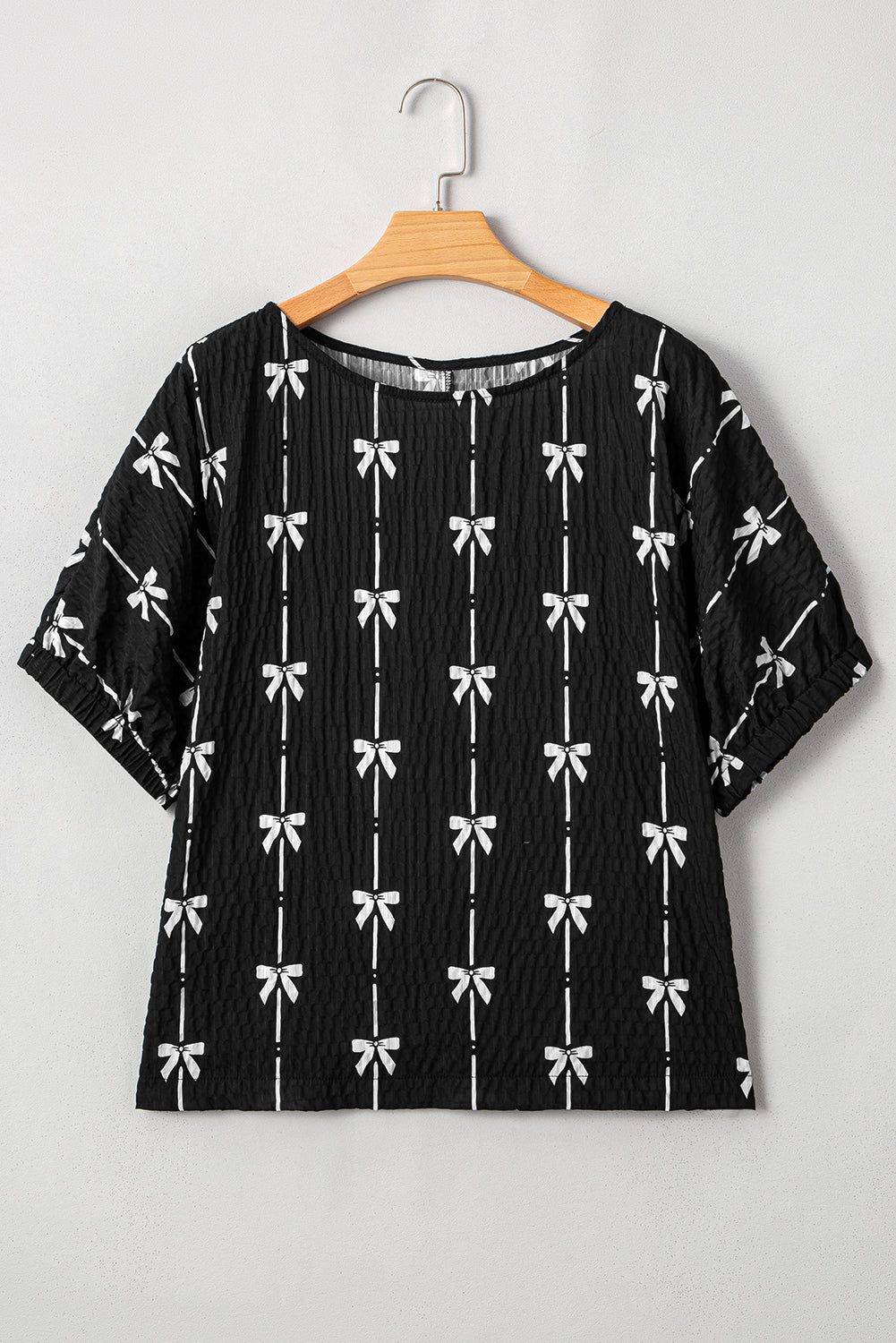 Black bow print puff short sleeve top by Mommas Hive, stylish blouse with puff sleeves and elegant bow pattern.
