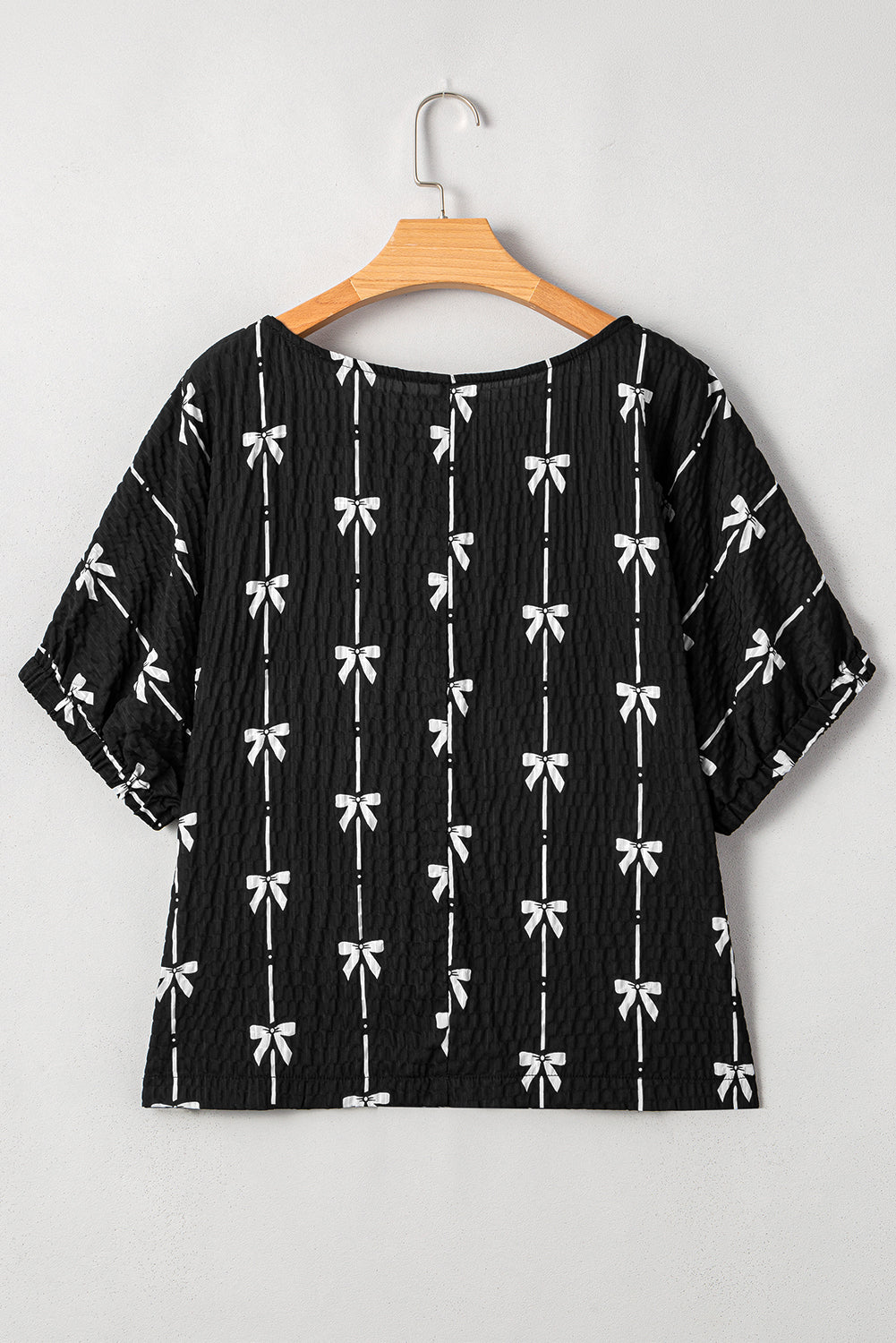 Black bow print puff short sleeve top by Mommas Hive, stylish blouse with short sleeves and a playful bow design.