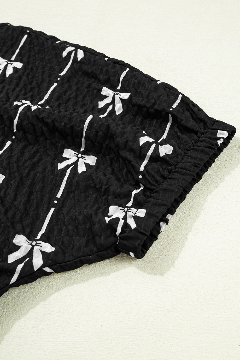 Black Bow Print Puff Short Sleeve Top by Mommas Hive, featuring a stylish bow pattern and lightweight polyester fabric.