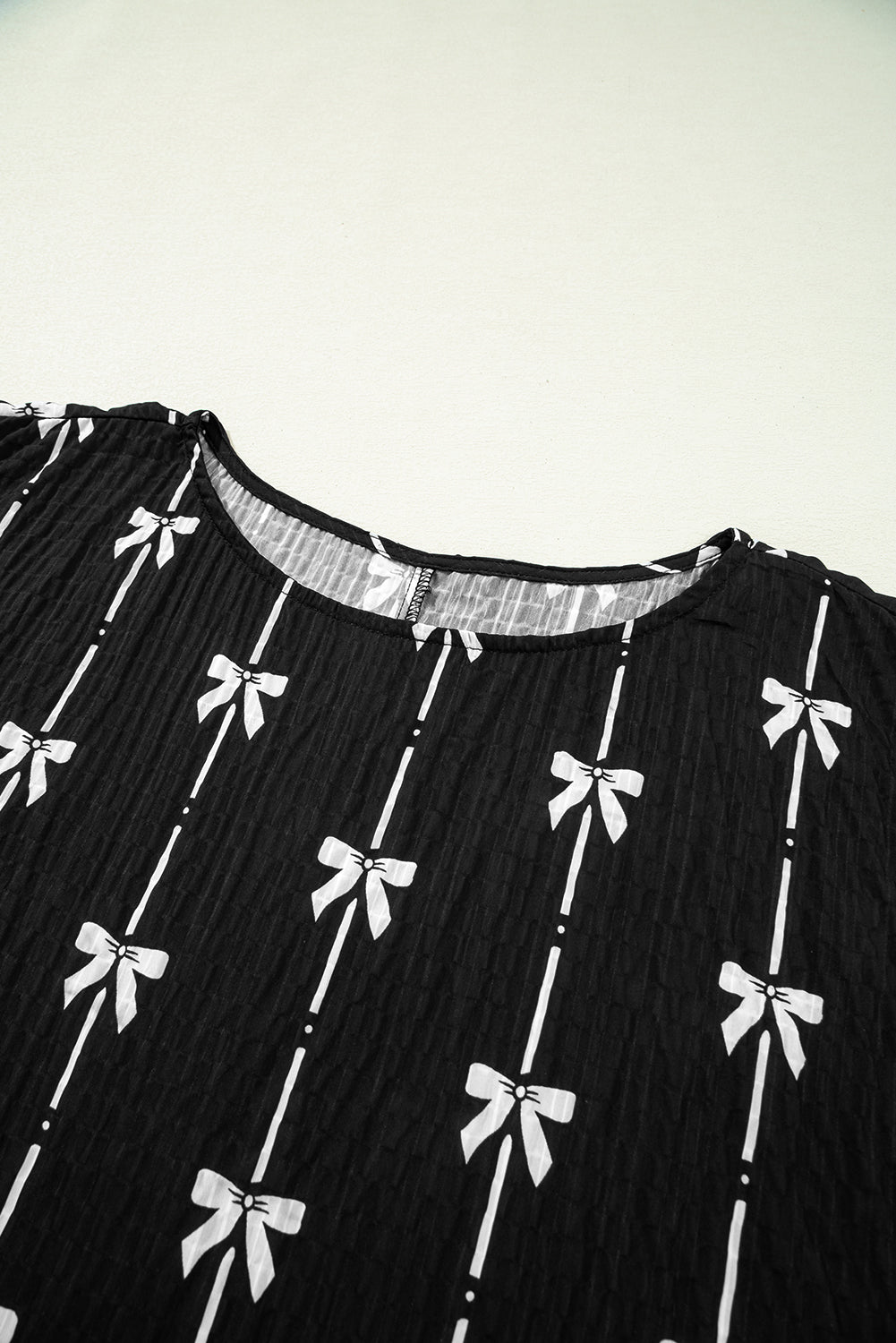 Black bow print puff short sleeve top by Mommas Hive, lightweight polyester blouse with feminine bow detail.