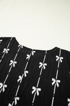 Black bow print puff short sleeve top by Mommas Hive, lightweight polyester blouse with a stylish bow detail and puffed sleeves.