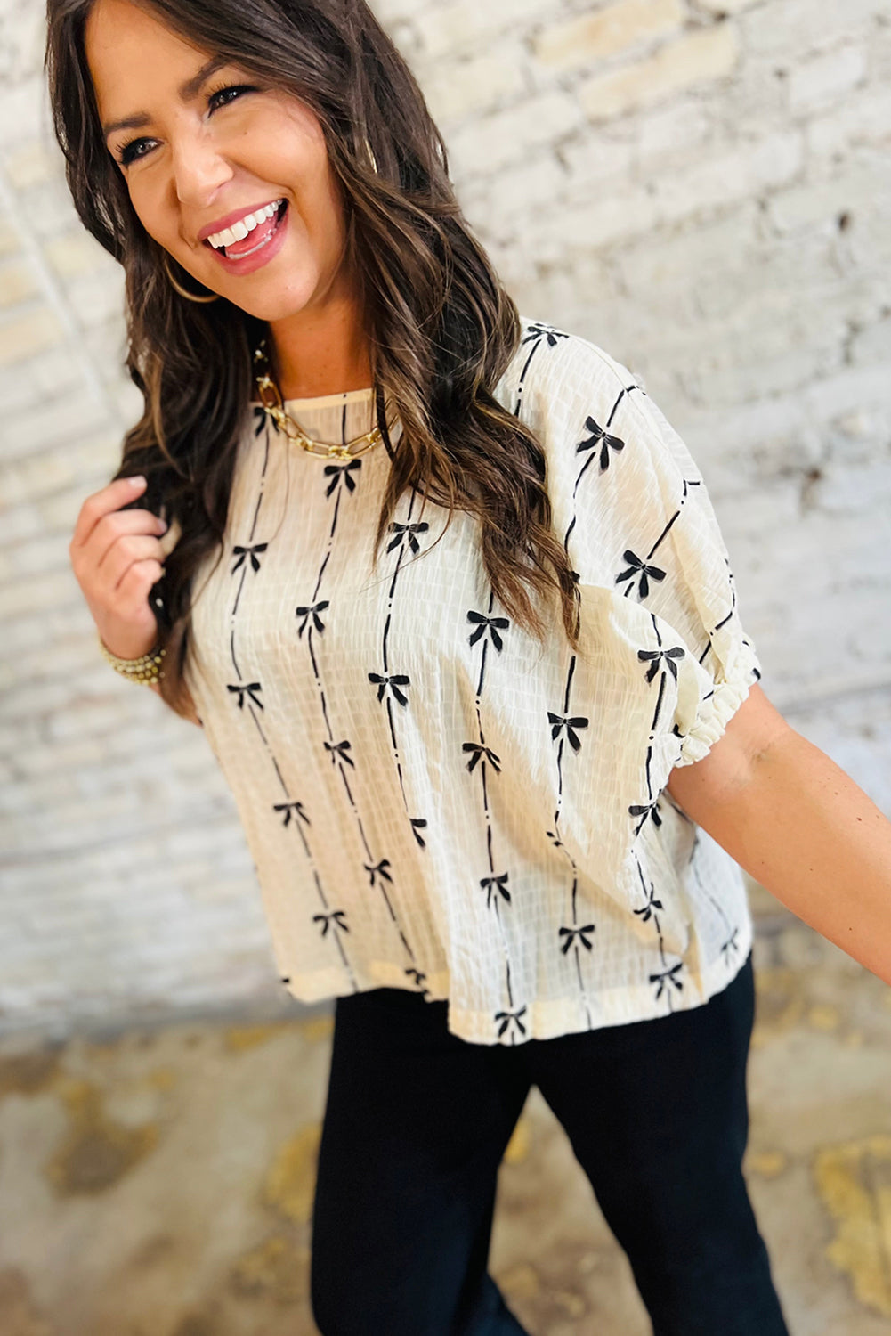 Black bow print puff short sleeve top by Mommas Hive, lightweight polyester blouse with a stylish bow pattern and puffed sleeves.