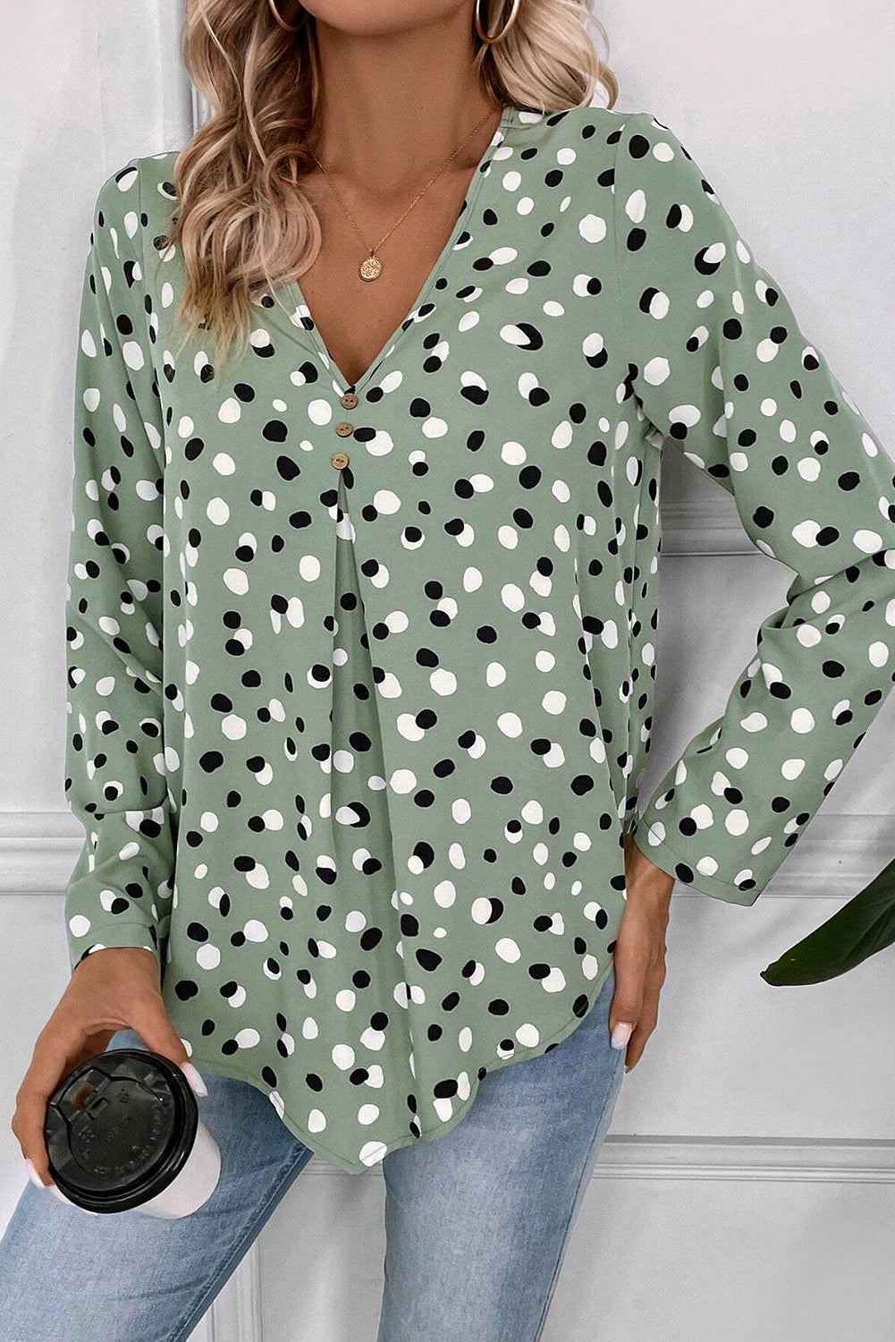 Green polka dot print blouse by Mommas Hive with button front and V-neck, made from lightweight polyester fabric.