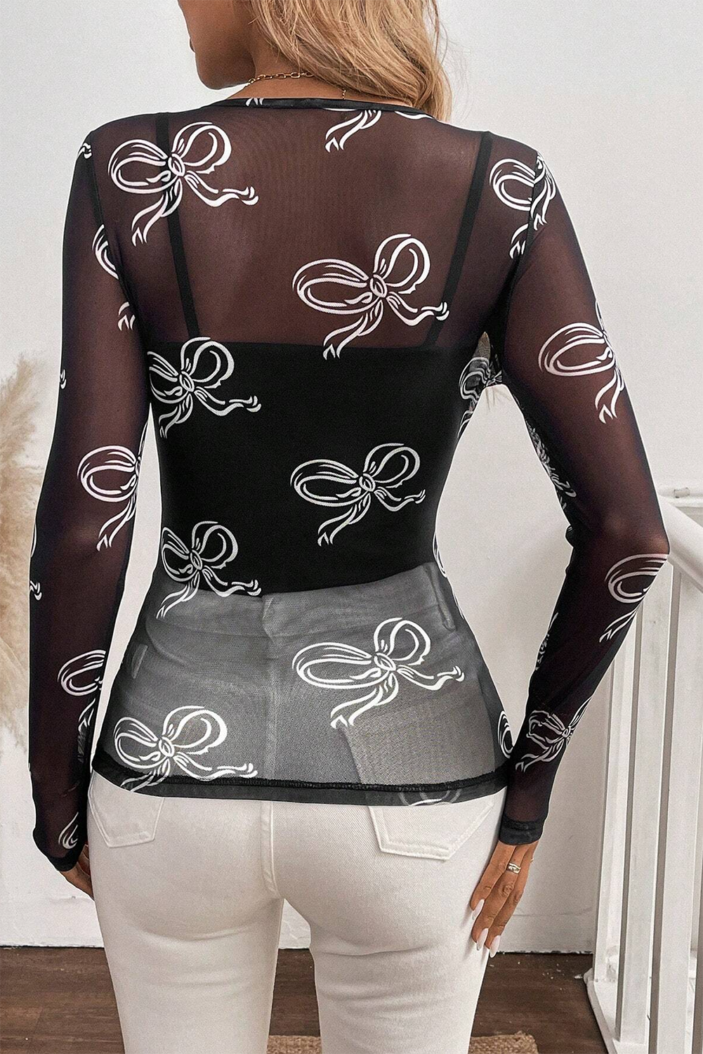 Black round neck mesh top with bow print from Mommas Hive, long sleeve design, lightweight polyester and elastane fabric.