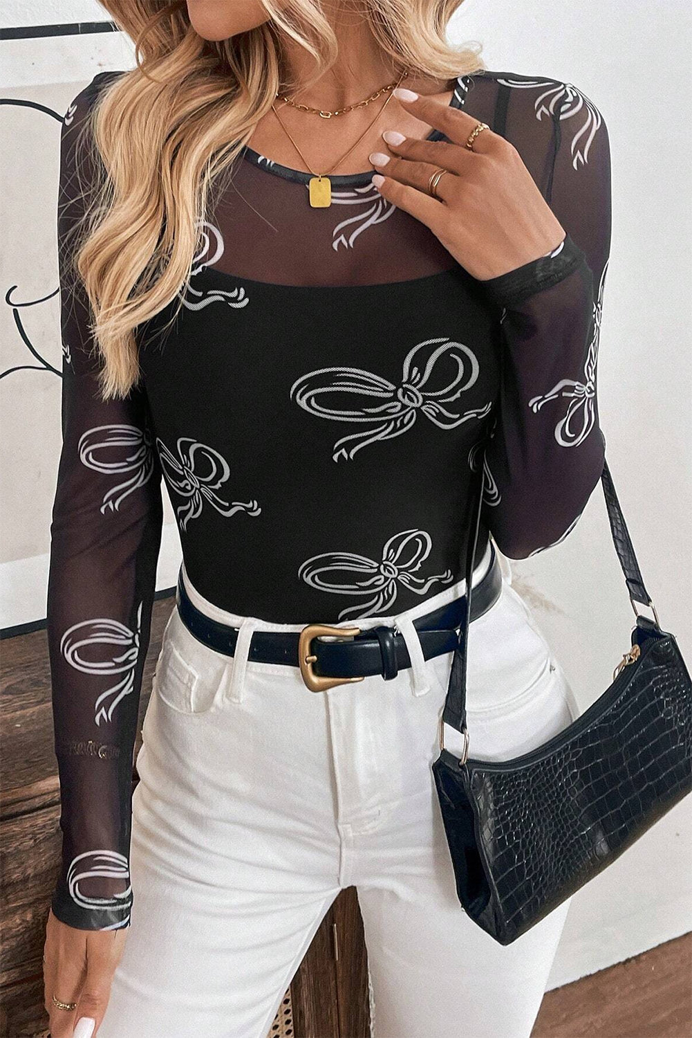 Black long sleeve mesh top with round neck and bow print by Mommas Hive, featuring a fitted design and sheer fabric.