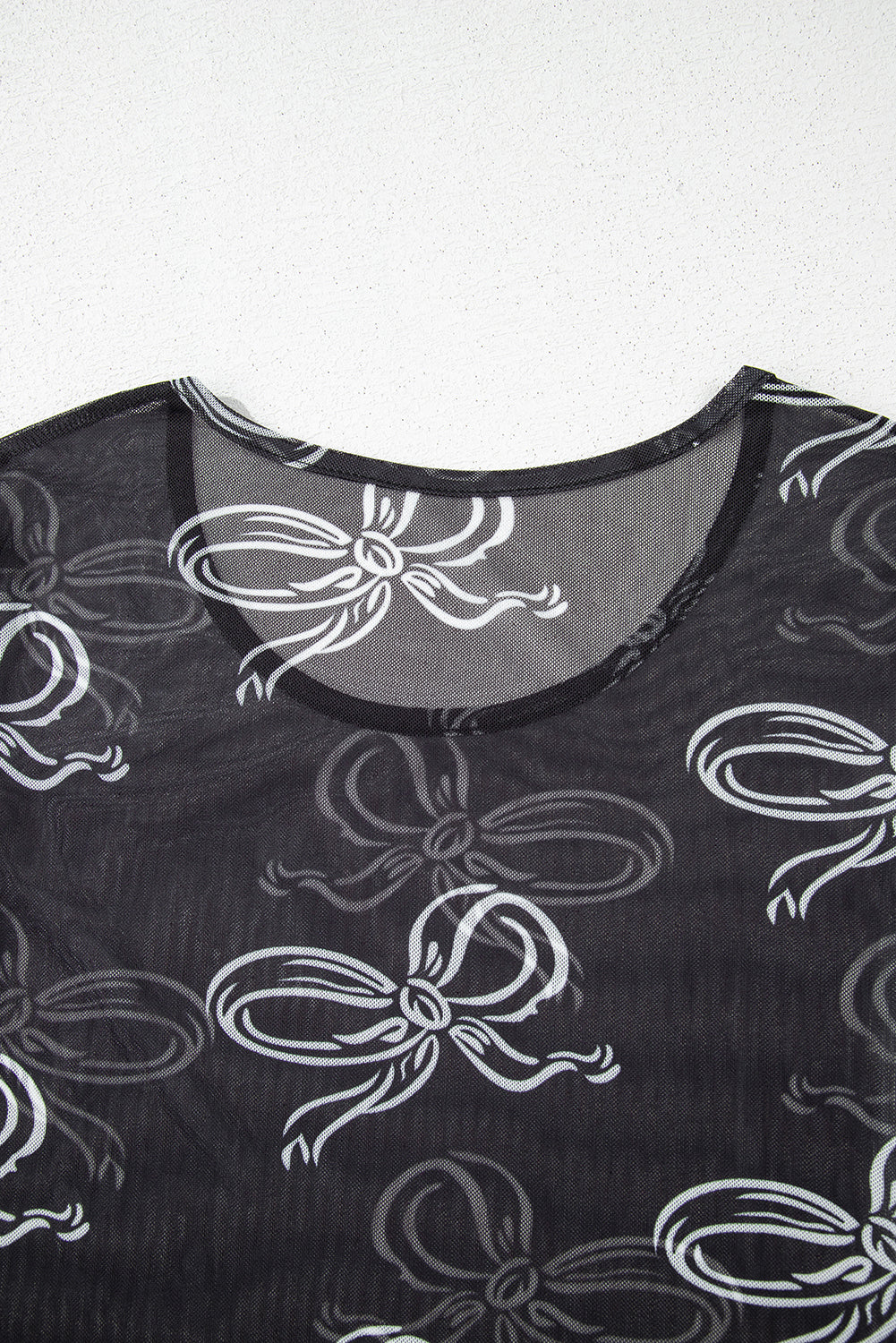 Black round neck long sleeve mesh top with bow print from Mommas Hive, featuring a fitted design and sheer fabric.