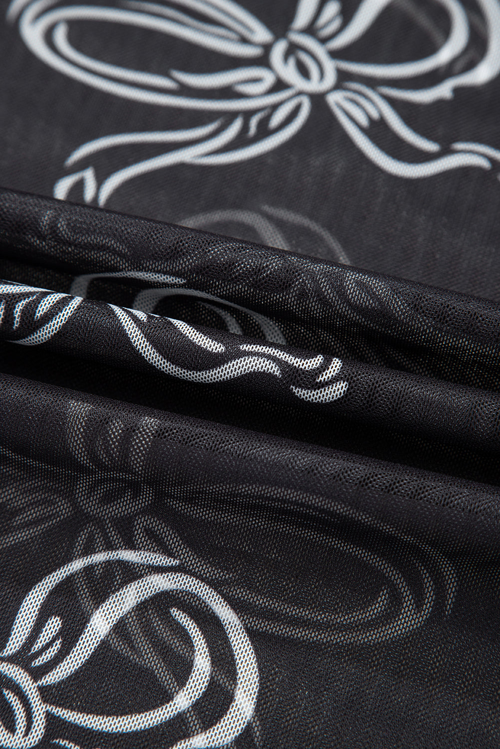 Black long sleeve mesh top with round neck and bow print from Mommas Hive, featuring polyester and elastane fabric.