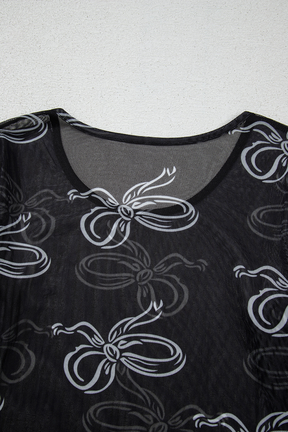Black long sleeve mesh top with bow print and round neck from Mommas Hive, stylish and lightweight for casual wear.