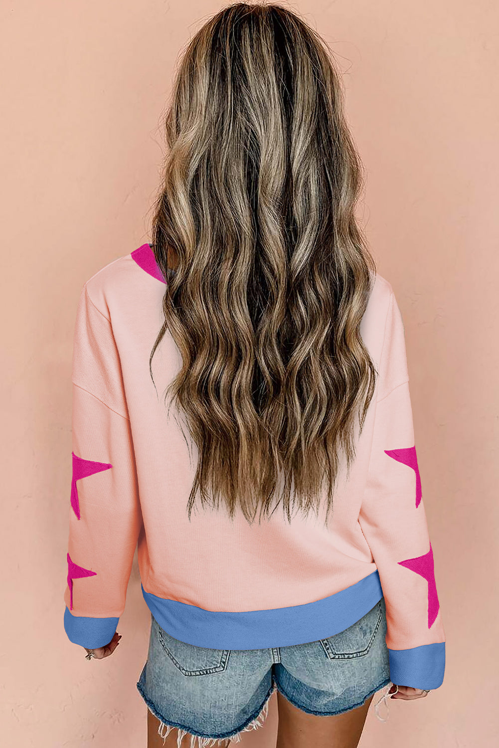 Light pink oversized sweatshirt by Mommas Hive with star patchwork and exposed seams, made of polyester and cotton blend.