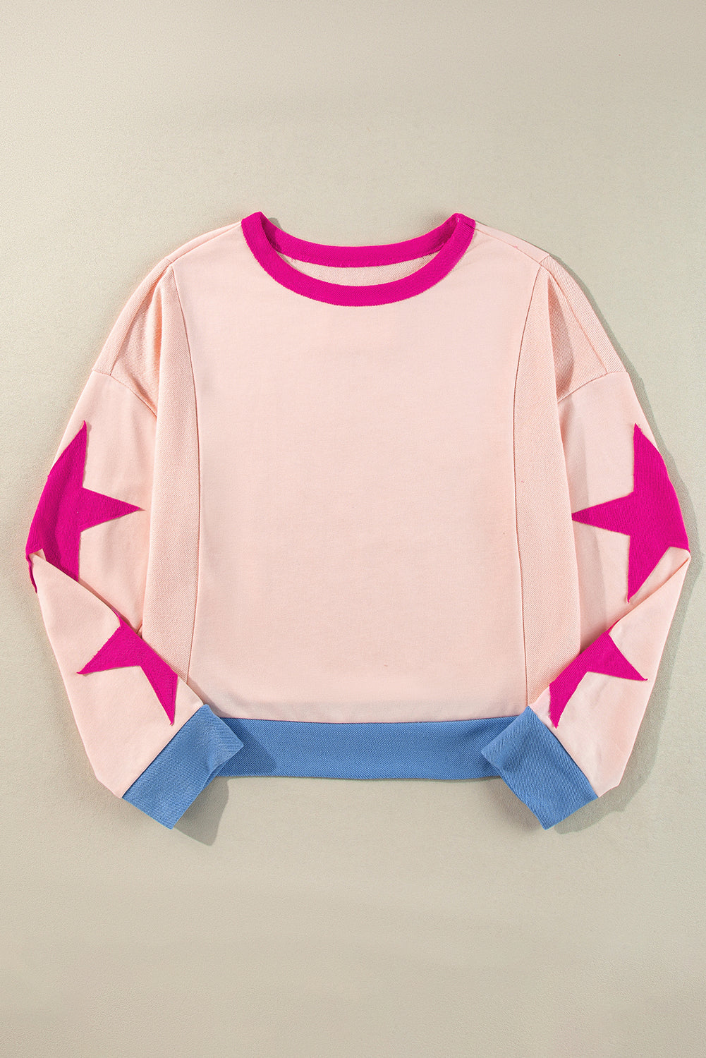 Light pink oversized sweatshirt with star patchwork and exposed seams from Mommas Hive, made of polyester and cotton blend.
