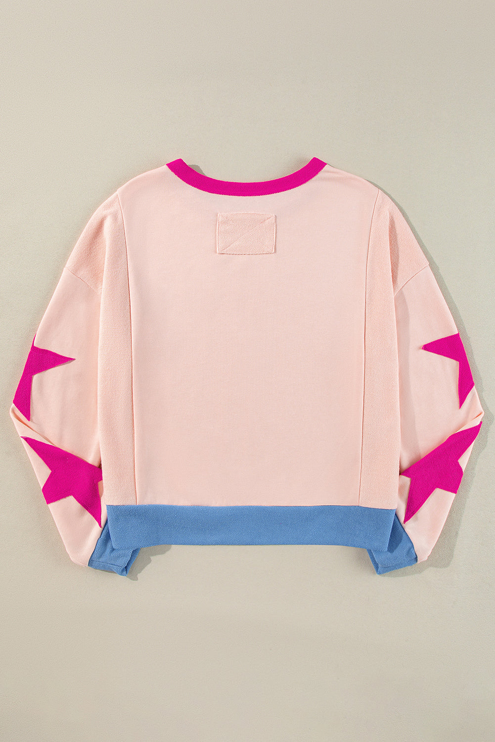 Light pink oversized sweatshirt with star patchwork and exposed seams from Mommas Hive, made of polyester and cotton.