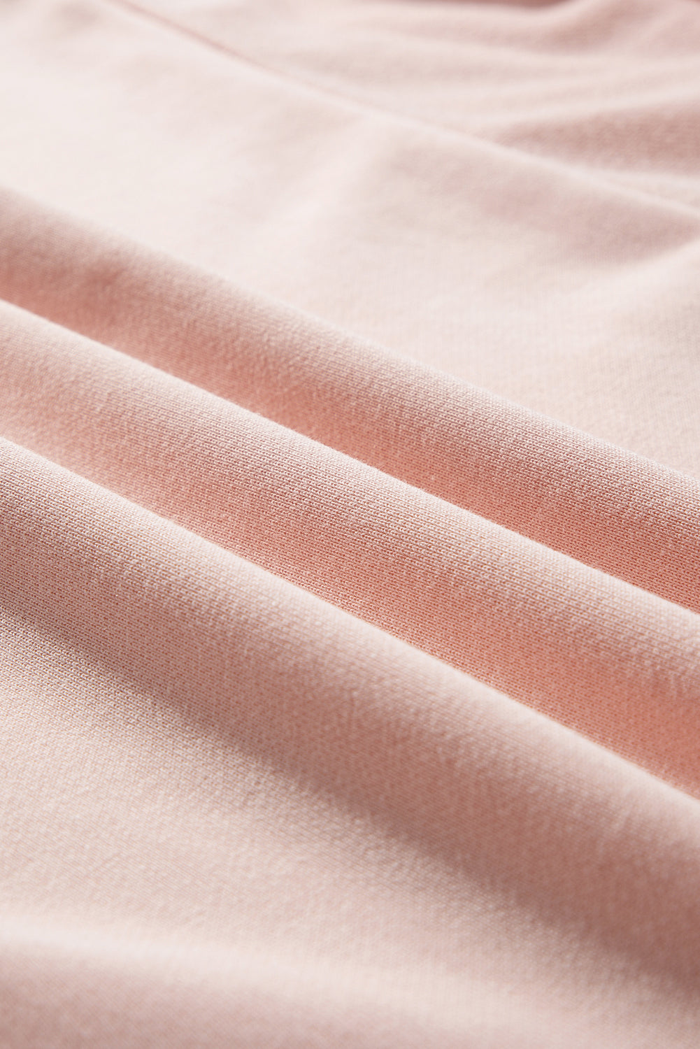 Light pink oversized sweatshirt by Mommas Hive with star patchwork, exposed seams, and a cozy, casual fit.