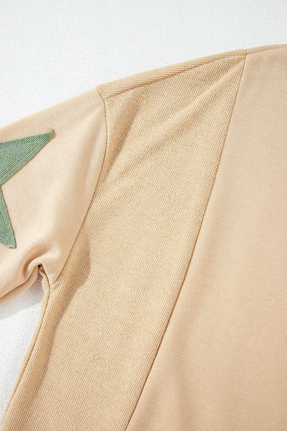 Light pink oversized sweatshirt by Mommas Hive with star patchwork and exposed seams, made of polyester and cotton blend.