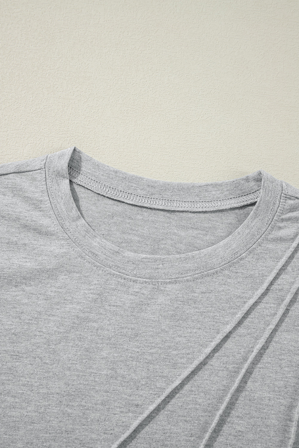 White crew neck pleated tank top from Mommas Hive, made of polyester, cotton, and elastane, shown on a hanger.