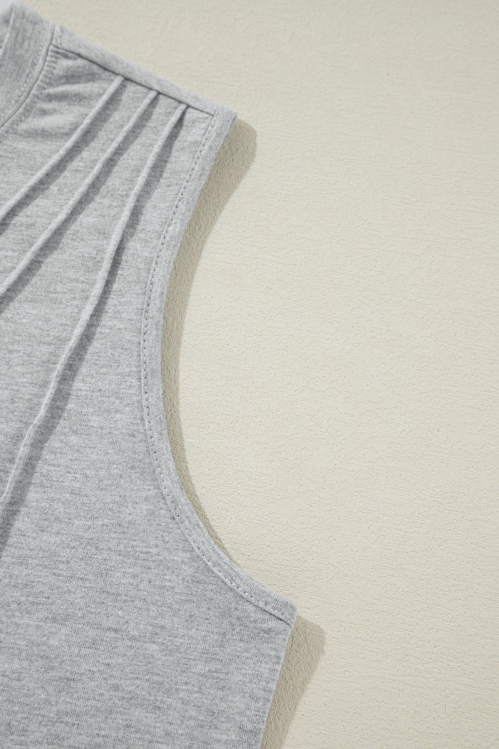 White crew neck pleated tank top from Mommas Hive, featuring a sleeveless design and lightweight fabric with polyester, cotton, and elastane.