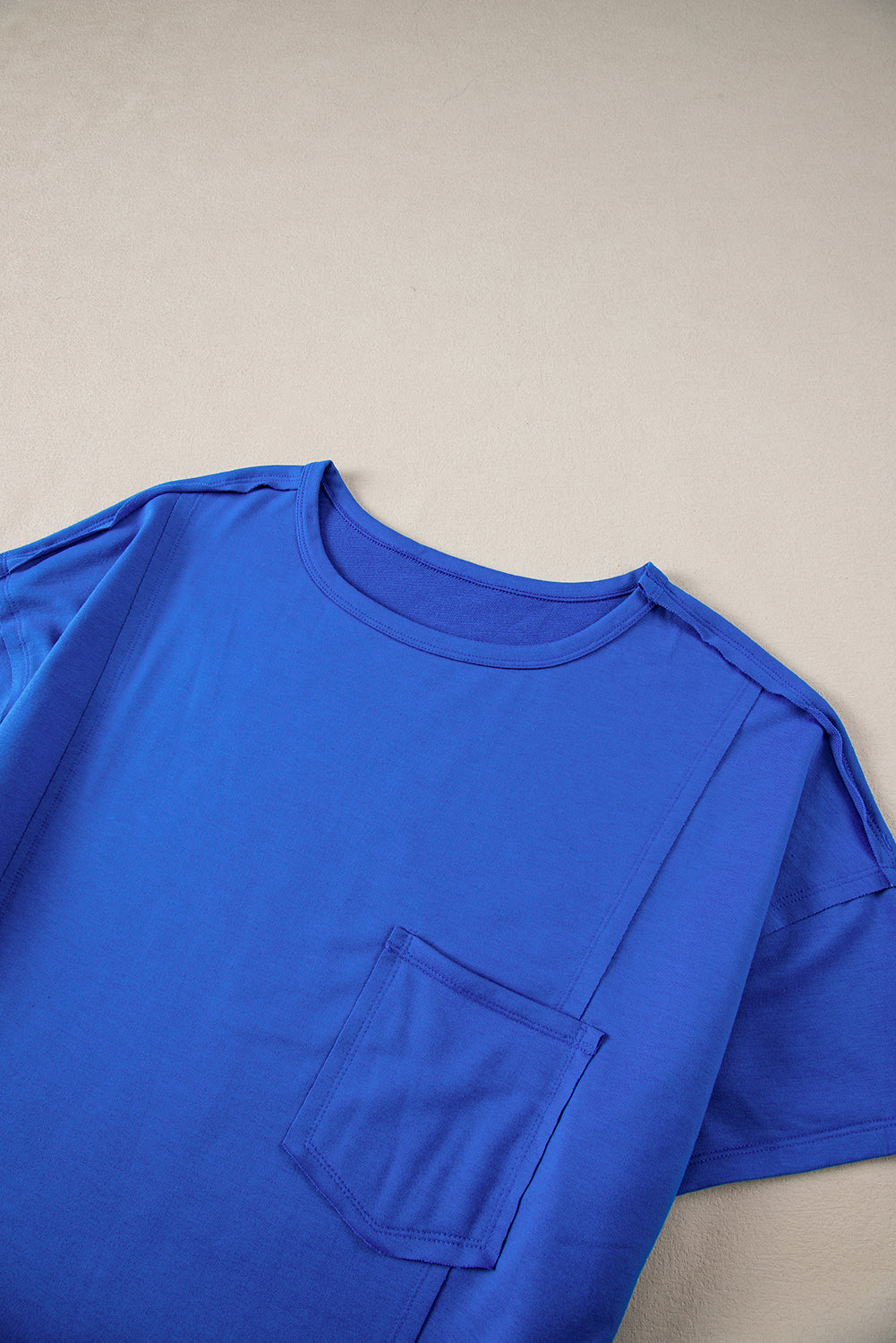 Blue oversized T-shirt from Mommas Hive with patched pocket and exposed seams, made of polyester, cotton, and elastane blend.