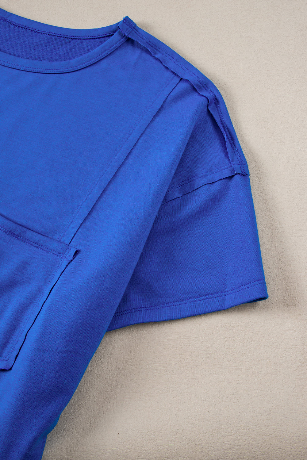 Blue oversized T-shirt by Mommas Hive with patched pocket and exposed seams, made from polyester, cotton, and elastane.